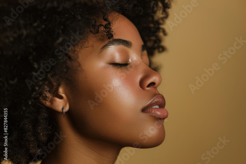 A close up of a black woman's face with her eyes closed looking to a side