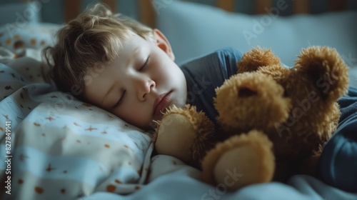 A young boy sleeping with a teddy bear.