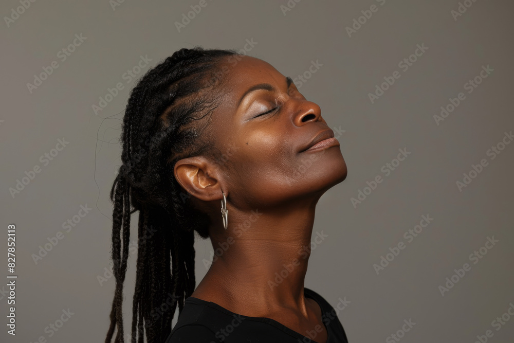 A close up of a black woman's face with her eyes closed looking to a side A close up of a black woman's face with her eyes closed looking to a side