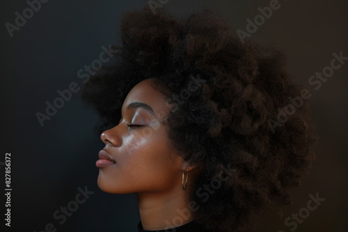 A close up of a black woman's face with her eyes closed looking to a side