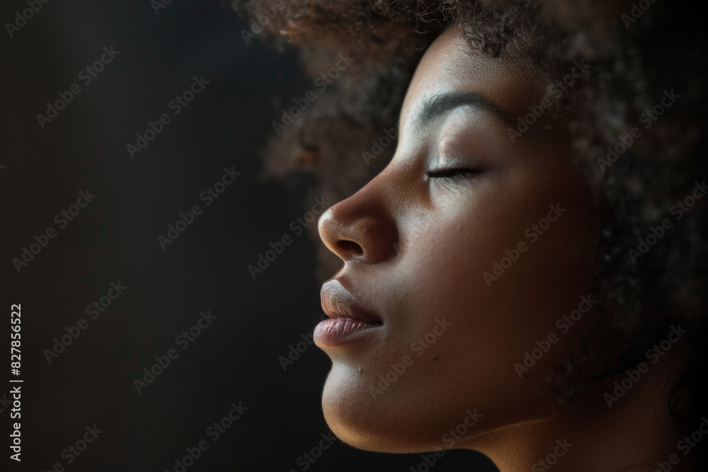 A close up of a black woman's face with her eyes closed looking to a side A close up of a black woman's face with her eyes closed looking to a side