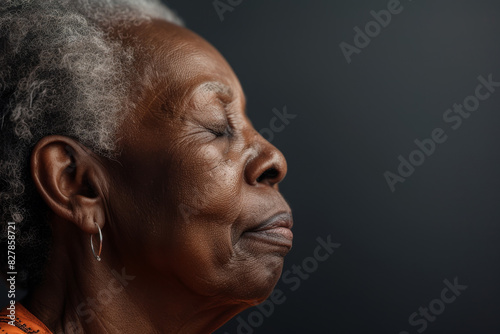 A close up of a black woman's face with her eyes closed looking to a side