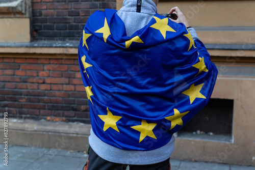 Man stands on his back covered in European Union flag 