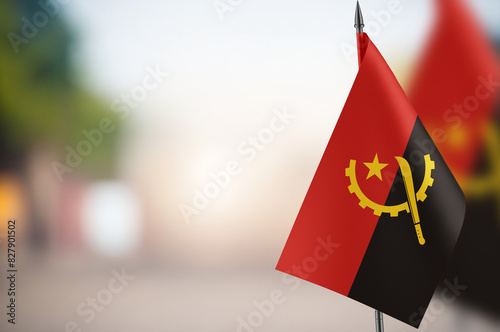 Small flags of Angola on a blurred background