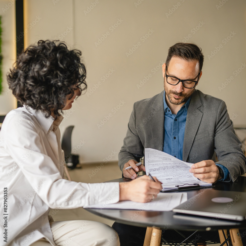 Mature woman sign insurance or contract to adult man in cafe Mature woman sign insurance or contract to adult man in cafe