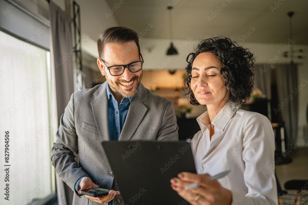 Colleagues stand in cafe woman hold document and man hold mobile phone Colleagues stand in cafe woman hold document and man hold mobile phone