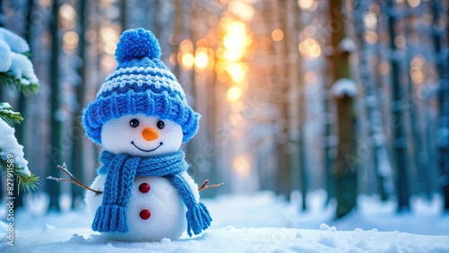 Cute snowman in a blue knitted bobble hat and scarf standing in a winter forest with copy space photo