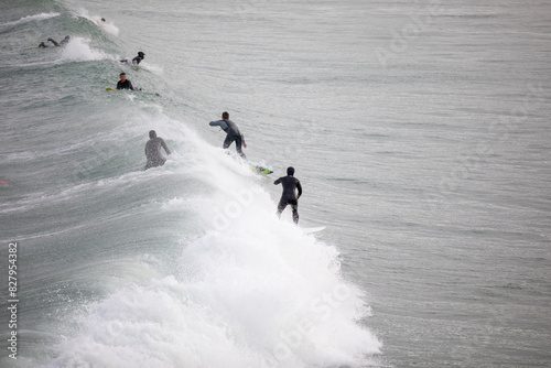 Photography People surfing waves at Great Western Beach in Newquay UK.