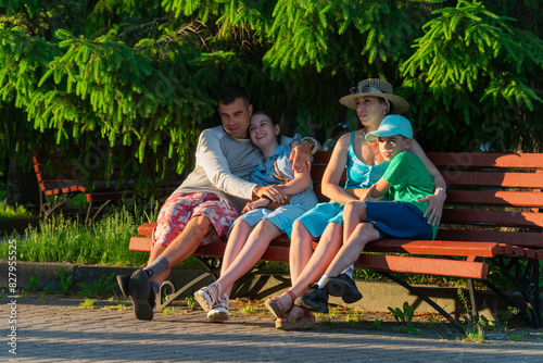 family resting on a bench, mom, dad, son, daughter, complete family, loving family