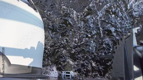 Water wash from astern or back of the boat.  Loose or broken water left behind by vessel propeller as it moves through water while boating at the lake with electric trolling motor.