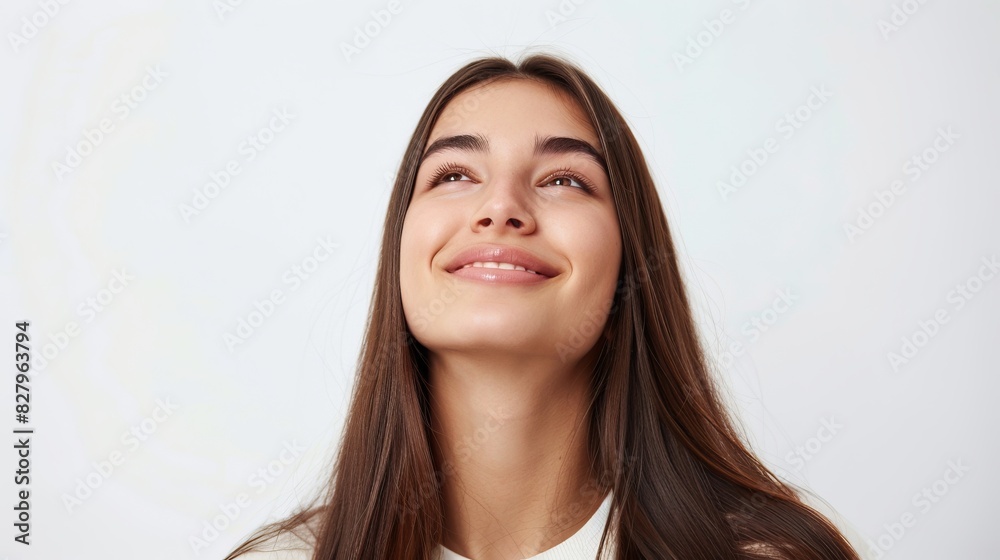 Dreamy young woman smiling and looking upwards on white background Dreamy young woman smiling and looking upwards on white background