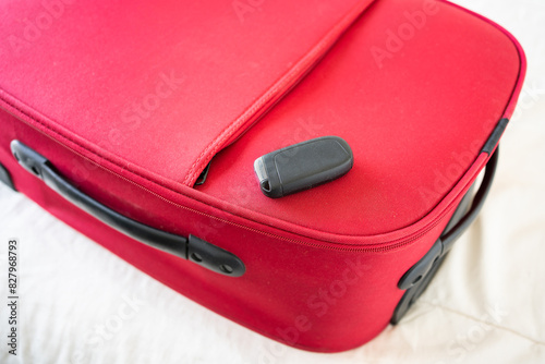 car key on a red suitcase as car travel concept