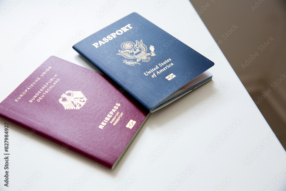 Close up of an American and German passports on white table Close up of an American and German passports on white table