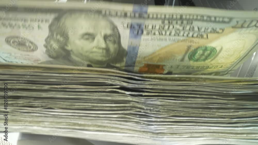 Finance and cash dollars concept. Counting dollars with electronic money counter machine. 100 dollar bills counted in money counting machine. Cash money dollars into banknote counter.
