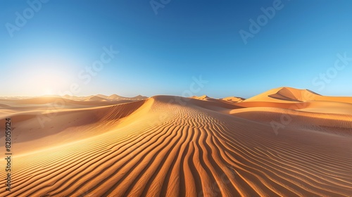 A stunning desert landscape captured at sunrise, with golden dunes and a clear blue sky in the background.
