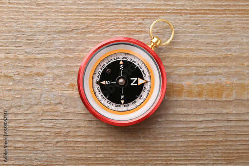 One compass on wooden table, top view