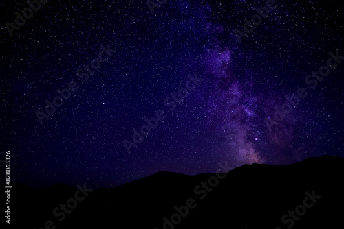 Sky with twinkling stars over mountains at night