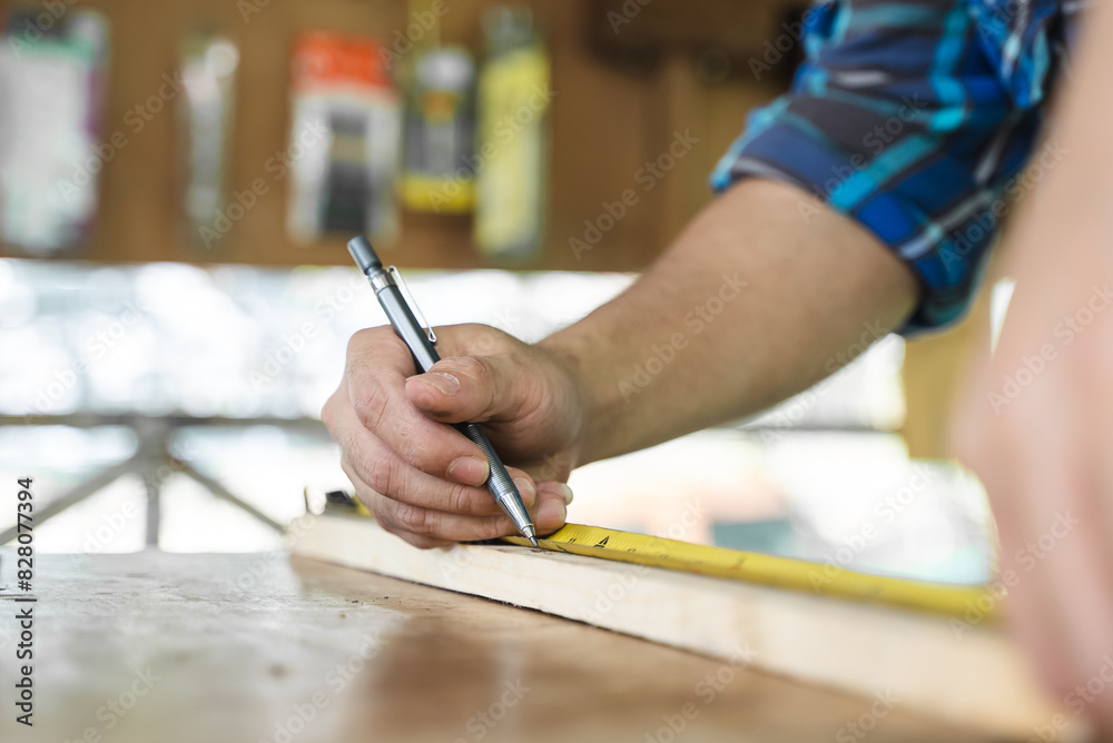 Hands of person doing diy project at home. Man measuring wood to doing cabinet craftworks as a hobby. Hands of person doing diy project at home. Man measuring wood to doing cabinet craftworks as a hobby.