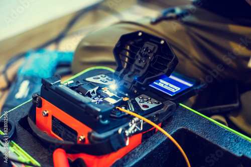 Selective focus to fiber optic splicing cable tools. Fixing Internet Cable. Technician is welding fiber optic cable at the job site.