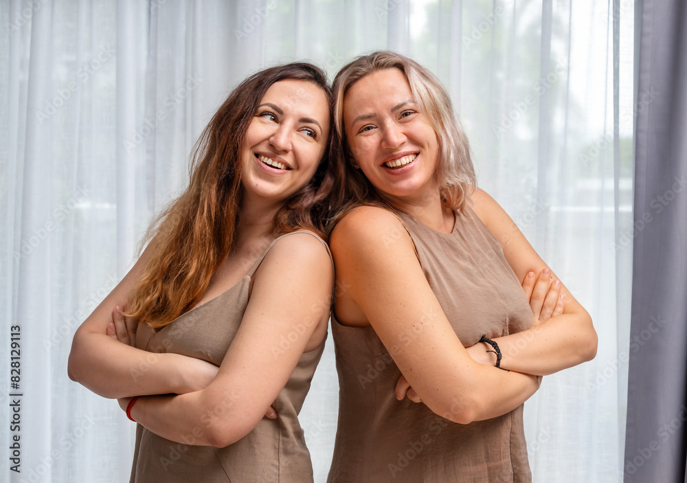 Fototapeta premium Portrait of adult sisters near the window
