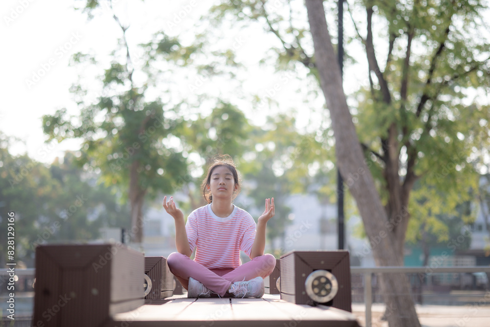 A girl is sitting on a bench in a park, meditating A girl is sitting on a bench in a park, meditating