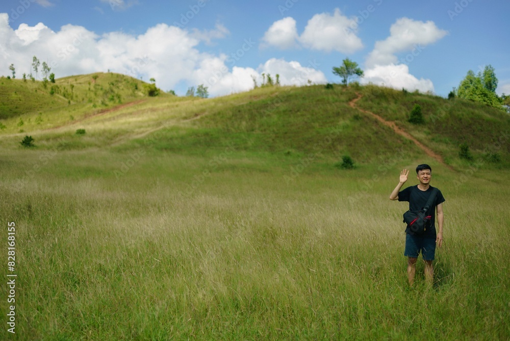 asian man standing in the field mountain in the background asian man standing in the field mountain in the background