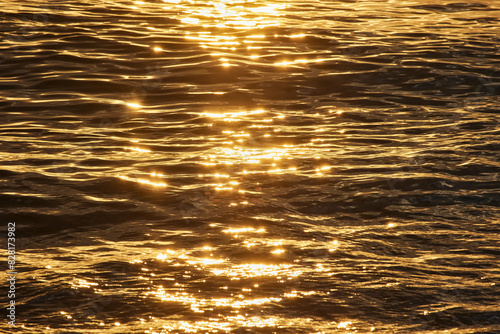 Fototapeta Naklejka Na Ścianę i Meble -  The surface of the sea glistens from the sun at sunset