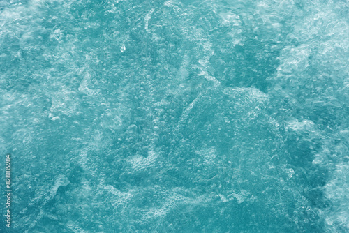 Bubbling water texture, flow thermal water as abstract background macro photo, spa and wellness theme, gentle ripples and gurgling on white turquoise aquatic surface, sea color gradient photo