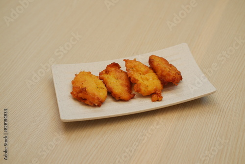 Corn croquettes on a white plate on a wooden table photo