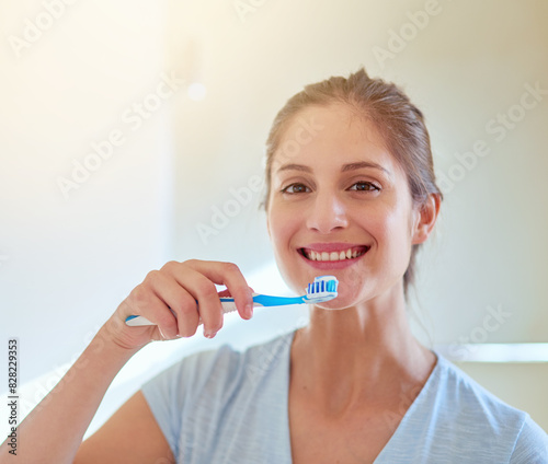 Woman, portrait and brushing teeth for cleaning in bathroom for gum hygiene, morning or health. Female person, face and dental care or whitening routine in home or wellness smile, treatment or breath