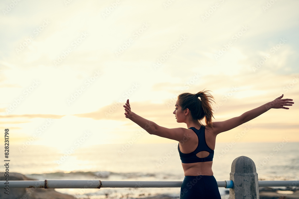 Back, woman and arms in air for sunset at beach for fitness, exercise and freedom in summer. Celebration, runner and success in nature for workout, training and ocean with achievement for wellness Back, woman and arms in air for sunset at beach for fitness, exercise and freedom in summer. Celebration, runner and success in nature for workout, training and ocean with achievement for wellness