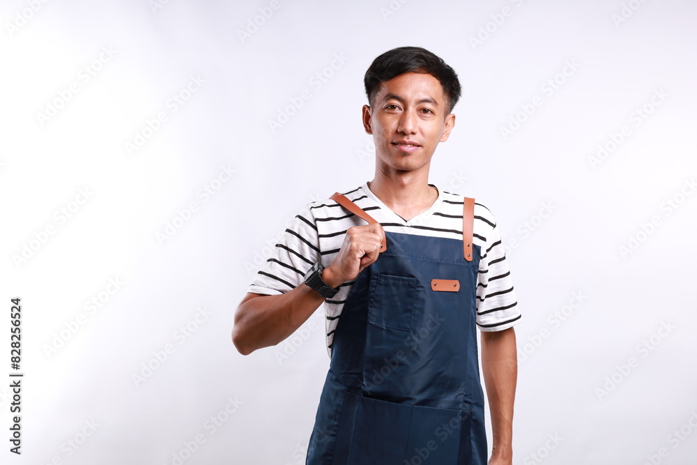 Confident asian barista in blue apron standing against white background. Waiter smiling and looking happy Confident asian barista in blue apron standing against white background. Waiter smiling and looking happy