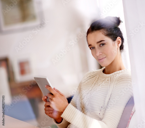 Tablet, relax and portrait of woman by window in living room reading ebook online for fantasy. Smile, calm and person enjoying romance novel or story on internet with digital technology at home.