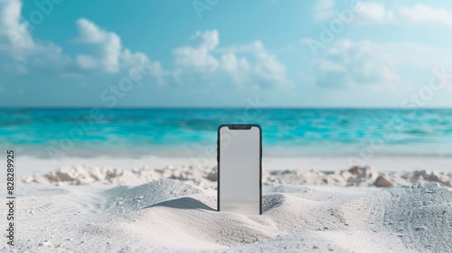 Mobile phone mockup with blank screen on the white sand on the tropical beach with blue water of the sea © Johannes