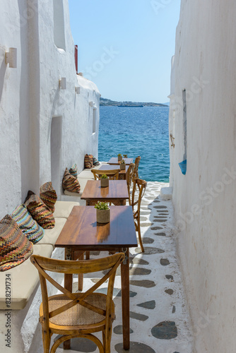 Traditional Cycladitic alley with a narrow street and an  exterior   of a tavern in Mykonos island, cyclades, Greece