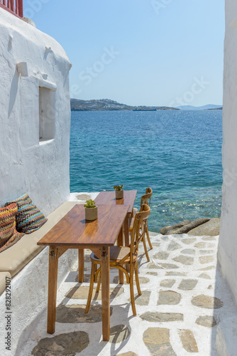 Traditional Cycladitic alley with a narrow street and an  exterior   of a tavern in Mykonos island, cyclades, Greece