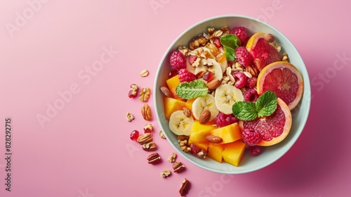 Top view of colorful fruit mix with nuts in a bowl. Healthy breakfast concept. Fresh fruit, raw food