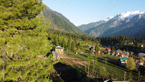 Beautiful landscape of Arang Kel in Kashmir with green fields and local houses with hidden in clouds photo