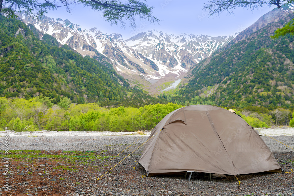 Camping tent outdoor. Camping leisure and destination travel near green forest mountain snow winter on the tents in morning. Tourism relax and chill in summer holiday.