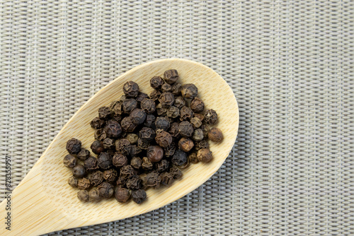 Pile of Black peppercorns Black pepper dried seeds on bamboo wooden background