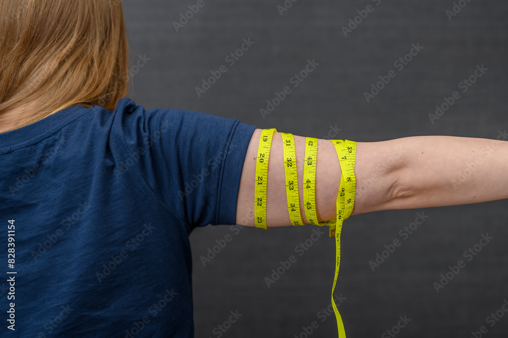 Naklejka premium Pomiar obwodów ciała, mierzyć ramiona centymetrem krawieckim