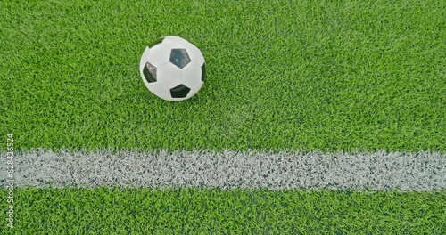 Soccer field impressions  - A passed soccer ball slowly rolls from the left to the right side, parallel to one of the soccer field's marking lines