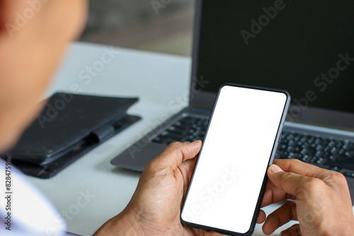 Fototapeta Naklejka Na Ścianę i Meble -  Man hands holding smart phone with blank copy space screen for your text message or information content, reading text message on cell telephone during in urban setting.