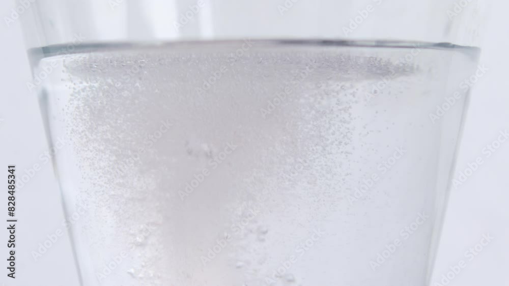 Closeup footage of the bubbles of an effervescent tablet dissolving in a glass of water
