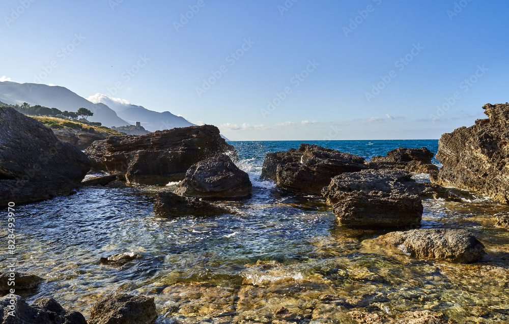 Rocky shore in Sicily is surrounded by mountains Rocky shore in Sicily is surrounded by mountains