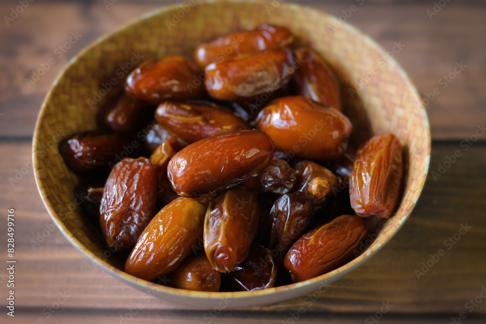 A plate of date fruit on wooden table A plate of date fruit on wooden table