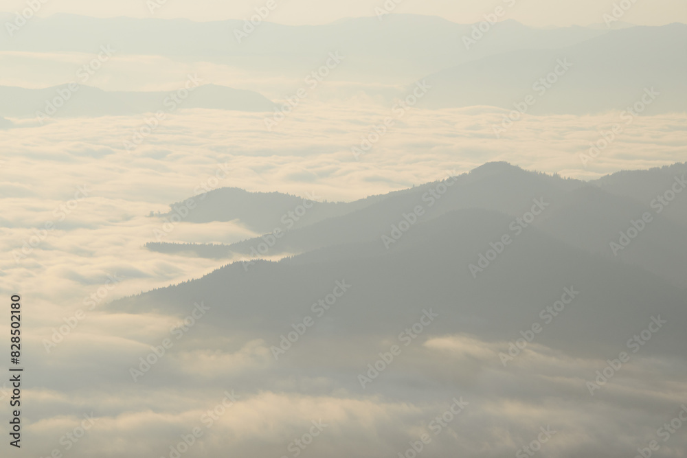 Misty clouds enveloping mountain peaks Misty clouds enveloping mountain peaks