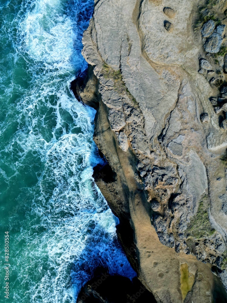 people are surfing in the ocean near some rocks and boulders people are surfing in the ocean near some rocks and boulders