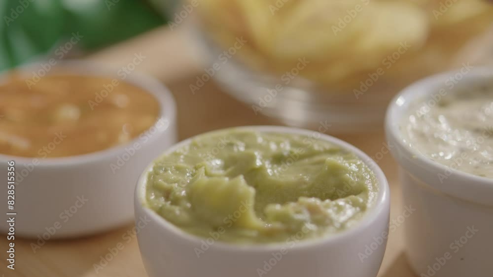 Close-up shot of a man dipping a banana chip into a sauce. Close-up shot of a man dipping a banana chip into a sauce.