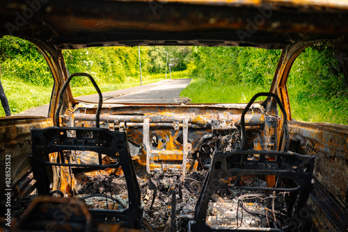 inside of a abandoned and burnt out car with the view of a public footpath outside the windscreen
